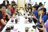 奥原選手（左列中央）らと食事をする生徒たち